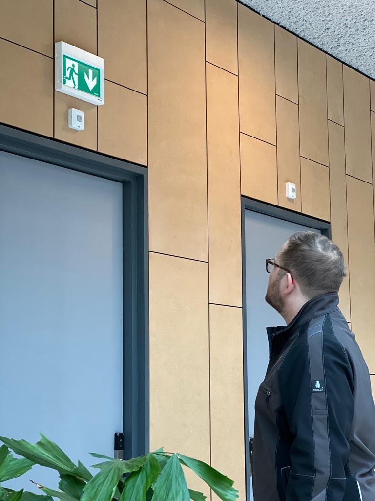 Huschka monteur voert visuele controle uit op noodverlichting